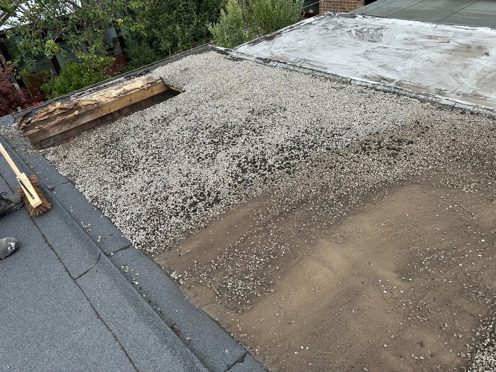 Deteriorating flat roof with damaged timber exposed at the edge