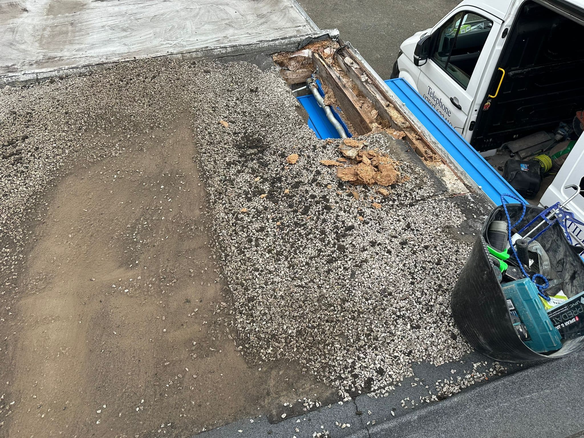 Water damage exposed beneath a flat roof during repair